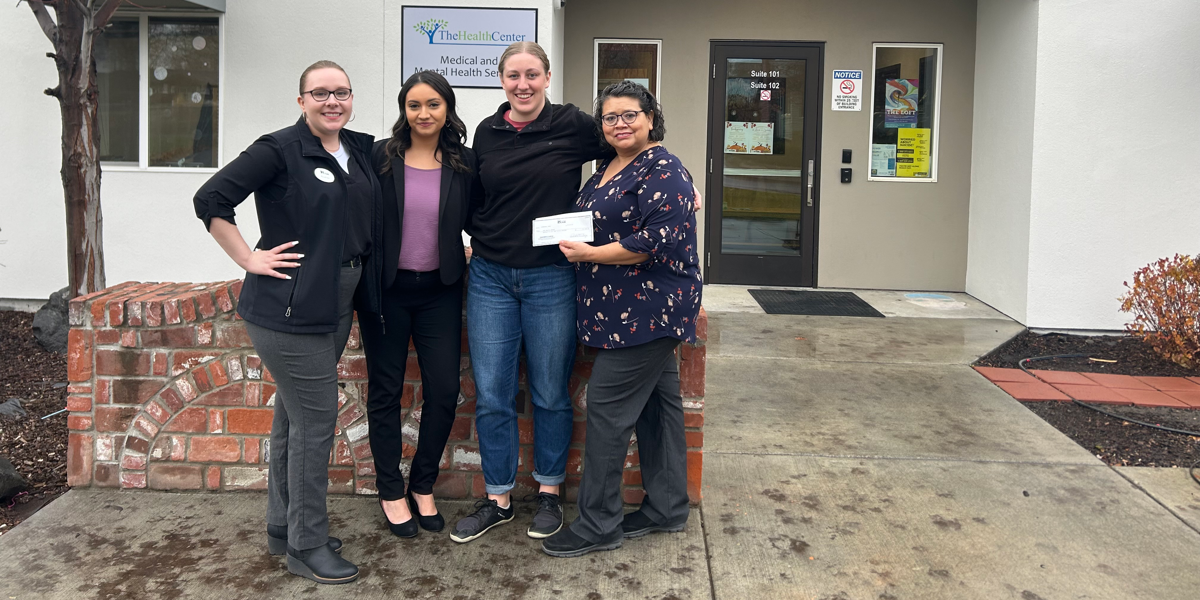 Andrea Retherford and Michelle Mendoza presenting  donation to representatives from the Health Center. 